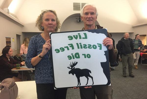 Couple holding sign Live Fossil Free or Die